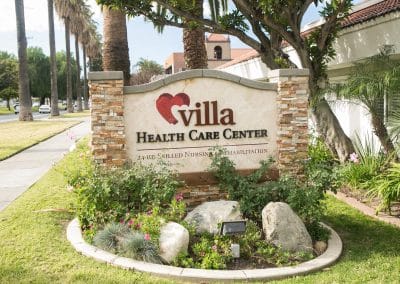 Front sign with beautiful plants and decorative rocks